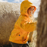 Girls rain jacket - Girl wears mustard yellow Wild Island kids raincoat with Australian seed pods pattern.