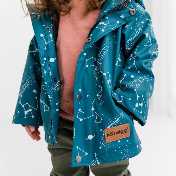 Girl wears Wild Island kids raincoat in ocean blue with vegan leather label