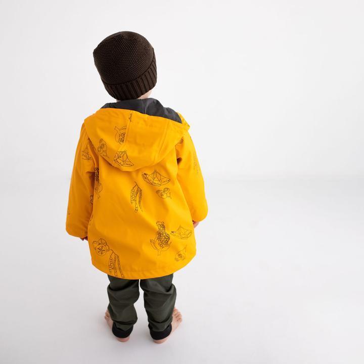 Boy wears mustard yellow Wild Island kids waterproof rain jacket for kids. 