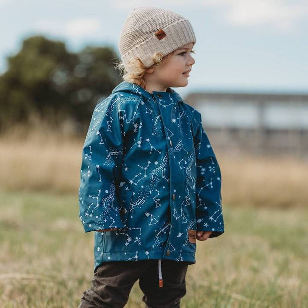 Boy wears Wild Island blue boys rain jacket on an outdoor adventure. 